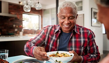 Senior man filling plate at table
