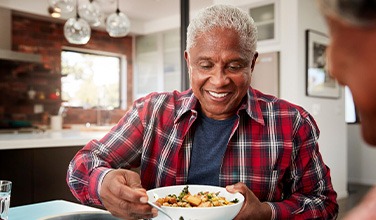 Senior man filling plate at table