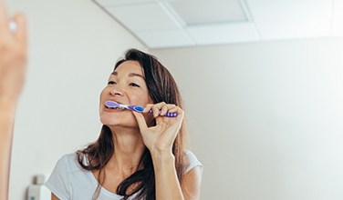 Woman brushing her teeth in bathroom