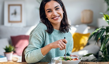 Smiling woman enjoying lunch at home