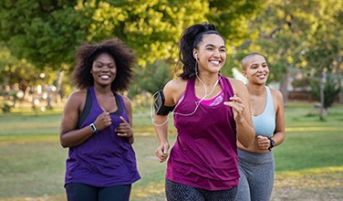 Group of women smiling while jogging in park
