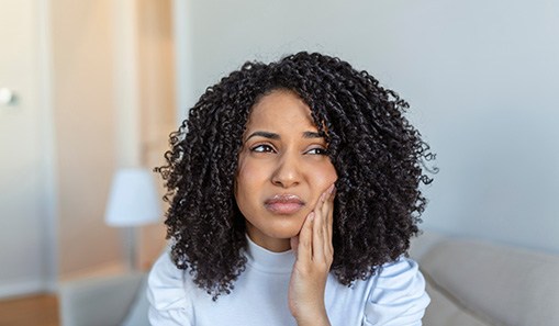 Woman experiencing toothache at home