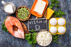 Foods rich in vitamin D surrounding chalkboard that says “Vitamin D.”