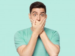 Man shocked and covering his mouth