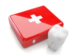 Red emergency kit with white first aid cross on front; tooth nearby.